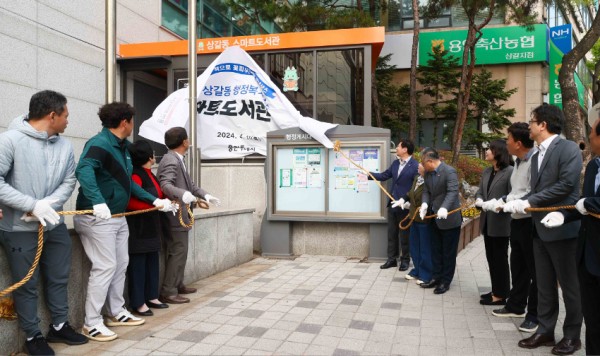 3-3. 지난 11일 기흥구 상갈동 행정복지센터 1층 야외 부스에서 열린 스마트도서관 11호점 개관식에서 이상일 용인특례시장(오른쪽에서 일곱번째) 등 참석자들이 제막식을 하고 있다..jpg